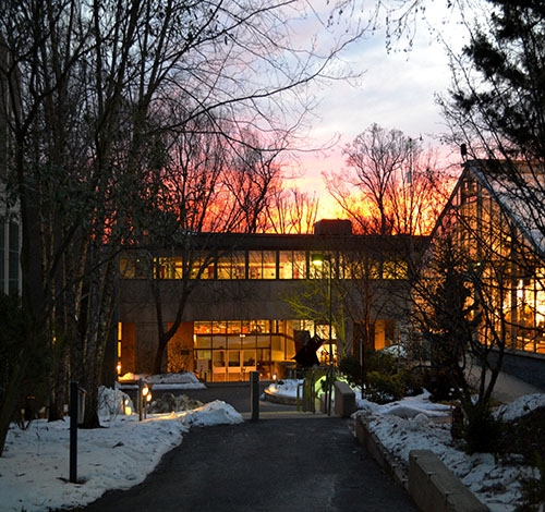 winter sunset seen through glass of lang music building on campus